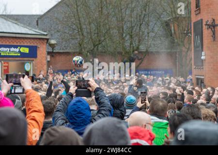 Ashbourne, Regno Unito. 13 febbraio 2024. Primo giorno della partita annuale di calcio Shrovetide nel villaggio di Ashbourne nel Derbyshire. Il gioco è giocato da due sezioni della città, gli Up'ards e i Down'ards. Le squadre dipendono da quale lato del brook Henmore è nato un giocatore. La partita si gioca in due giorni, martedì grasso e mercoledì delle ceneri, con due periodi di otto ore con i gol a tre miglia di distanza. Non c'è limite al numero di giocatori e si applicano pochissime regole. Penelope Barritt/Alamy Live News Foto Stock