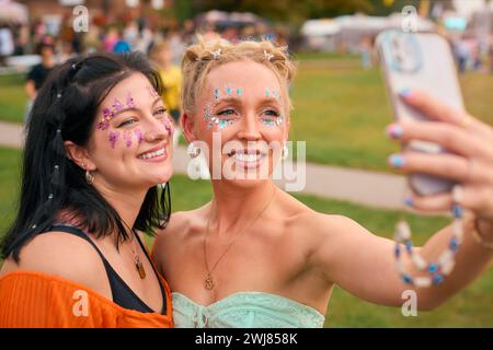 Due amiche che indossano glitter in posa per Selfie al Summer Music Festival Foto Stock