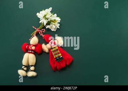 Un mazzo di fiori di nevicata e una martenitsa rossa-bianca, simbolo della festa del 1° marzo, Martisor, Baba Marta. Foto Stock