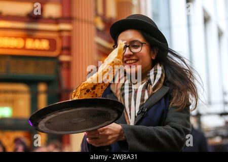 Londra, Regno Unito. 13 febbraio 2024. Un partecipante prende parte alla gara annuale di Shrove pancake Day al mercato di Leadenhall nel centro di Londra. Ospitato dal pub del XVIII secolo Markets C, l'Lamb Tavern C, l'evento tradizionale annuale, le squadre competono per la gloria durante una staffetta di 20 metri sui mercati coperti vittoriani antichi ciottoli. Credito: SOPA Images Limited/Alamy Live News Foto Stock