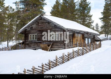 Tradizionale casetta in legno e recinzione in inverno. Girato in Svezia, Scandinavia Foto Stock
