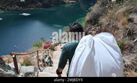 Giovane escursionista che scende per il sentiero di montagna. Escursionista che cammina verso il lago su un sentiero di montagna. Uomo che cammina in forma camminando nella natura, inseguimento Foto Stock