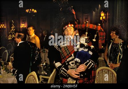 Festa di Capodanno al Ritz Hotel. Una cena danzante e ospiti che celebrano l'arrivo del nuovo anno con un cornamusa scozzese Hogmany, piping nel nuovo anno. Londra, Inghilterra 31 dicembre 1986. 1980 UK HOMER SYKES Foto Stock