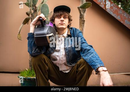 Giovane ed elegante abbigliamento hipster maschile in stile anni '90 retrò e vecchio stile regge il lettore di cassette audio. Foto Stock