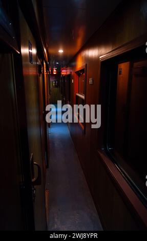 Corridoio d'epoca vuoto di vagone letto ferroviario al crepuscolo. Foto Stock