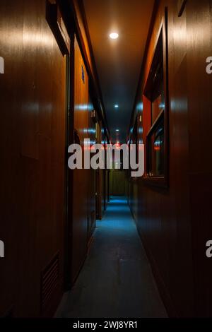 Corridoio d'epoca vuoto di vagone letto ferroviario al crepuscolo. Foto Stock