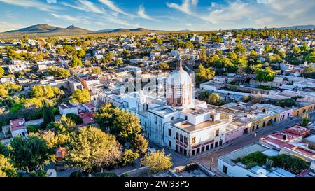 Ampio panorama aereo del "Pueblo Mágico" Mineral de Pozos, che mette in risalto l'iconica cupola parrocchiale in mezzo all'affascinante scenario del villaggio. Foto Stock