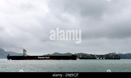 Navi container che attraversano il trafficato canale di East Lamma a Hong Kong. Foto Stock