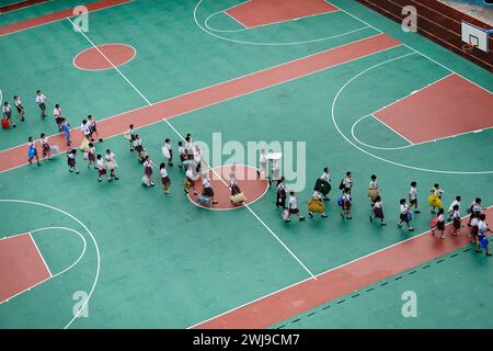 I bambini delle scuole camminano sul campo da basket della scuola. Shenzhen, Cina. Foto Stock