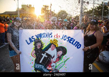 Barranquilla, Colombia. 13 febbraio 2024. Un gruppo di partecipanti dell'ultimo giorno del carnevale tiene una pancard dicendo che le vedove di Joselito nell'ultimo giorno del carnevale di Barranquilla, Joseilito, l'anima del carnevale muore. La sfilata è fatta dalla Regina del Carnevale e i cittadini, che organizzati in diversi gruppi stanno eseguendo il funerale di Joselito e le sue vedove, portano le bare di Joselito e piangono per lui durante la sfilata. Credito: SOPA Images Limited/Alamy Live News Foto Stock