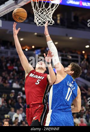 Milwaukee, Stati Uniti. 13 febbraio 2024. Nikola Jovic (L), attaccante dei Miami Heat, guida al basket durante la partita di stagione regolare 2023-2024 tra i Miami Heat e i Milwaukee Bucks al Fiserv Forum di Milwaukee, negli Stati Uniti, il 13 febbraio 2024. Crediti: Joel Lerner/Xinhua/Alamy Live News Foto Stock