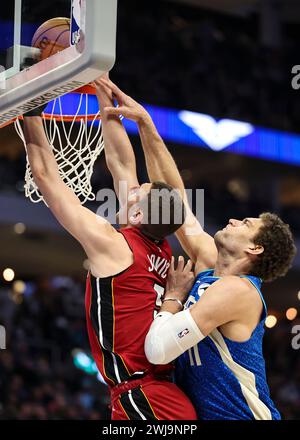 Milwaukee, Stati Uniti. 13 febbraio 2024. Il centro dei Milwaukee Bucks Brook Lopez (R) blocca il tiro dell'attaccante dei Miami Heat Nikola Jovic durante la partita di stagione regolare NBA 2023-2024 tra i Miami Heat e i Milwaukee Bucks al Fiserv Forum di Milwaukee, negli Stati Uniti, il 13 febbraio 2024. Crediti: Joel Lerner/Xinhua/Alamy Live News Foto Stock