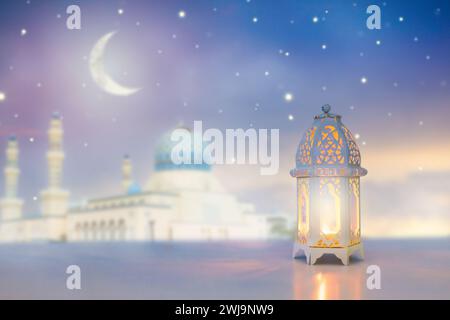 Saluto Ramadan Kareem. Lanterna islamica vicino alla moschea con cielo notturno con luna crescente e stelle. Fine del digiuno. Carta Hari Raya. Foto Stock