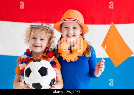 I bambini fanno il tifo e sostengono la squadra di calcio olandese. Tifosi per bambini e tifosi dei Paesi Bassi durante il campionato di calcio. Foto Stock