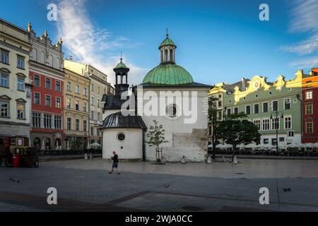 Chiesa di S.. Adalbert, alias Chiesa di S.. Wojciech e la piazza principale di Cracovia la mattina presto, con pochissime persone Foto Stock