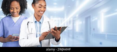 Due professionisti medici impegnati, uno in una scrub blu e l'altro in un cappotto bianco Foto Stock