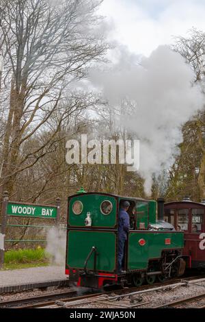 Locomotiva a vapore a scartamento ridotto "Axe" in procinto di tirare un treno fuori dalla stazione di Woody Bay sulla ferrovia Lynton and Barnstaple, Devon, Regno Unito Foto Stock