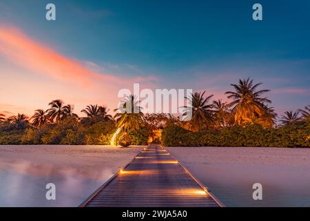 Splendida spiaggia al tramonto. Nuvole di cielo colorate che irradiano i raggi del sole sulle palme. Paesaggio panoramico dell'isola, calmi riflessi del mare rilassatevi tropicali Foto Stock