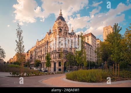 Storico edificio ornato con una facciata decorativa crogiola alla luce dolce del tramonto, che mostra il fascino dell'architettura urbana europea Foto Stock