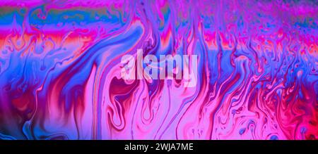 Motivo marmorizzato astratto caratterizzato da una vivace miscela di tonalità rosa, blu e viola con vortici e onde fluide Foto Stock