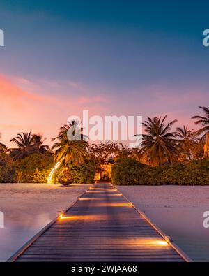 Splendida spiaggia al tramonto. Nuvole di cielo colorate che irradiano i raggi del sole sulle palme. Paesaggio panoramico dell'isola, calmi riflessi del mare rilassatevi tropicali Foto Stock