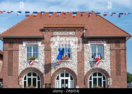 Facciata di un municipio con una bandiera francese blu, bianca e rossa e una bandiera europea in occasione della festa nazionale del 14 luglio, e motto sul Foto Stock