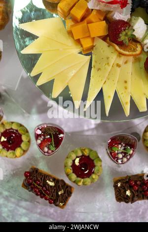 Stuzzichini e dessert colorati e deliziosi su una vetrata durante un evento di catering Foto Stock