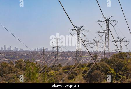 Linee elettriche ad alta tensione attraversano il Bush del Churchill National Park in viaggio verso Melbourne, Australia, in lontananza. Foto Stock