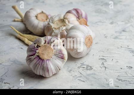 Spicchi d'aglio e bulbo in lampadine d'aglio su cemento leggero.Vista dall'alto spicchi d'aglio freschi. Concetto di stile di vita sano. L'aglio antivirale e medicinale aiuta Foto Stock