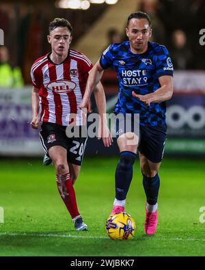 Kane Wilson (a destra) di Derby County e Luke Harris di Exeter City si battono per il pallone durante la partita Sky Bet League One a St James Park, Exeter. Data foto: Martedì 13 febbraio 2024. Foto Stock