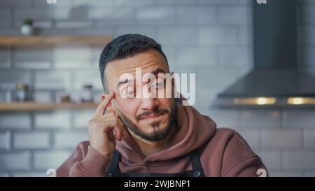 Uomo che pensa all'idea e trova la soluzione. Gli uomini riflettono profondamente nei pensieri che sognano una soluzione di ricerca, difficili riflessioni creative e ponderate in cucina Foto Stock