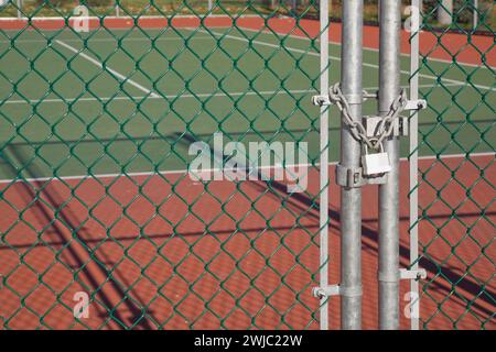 Recinzione di sicurezza a catena con lucchetto presso il campo da tennis. Foto Stock