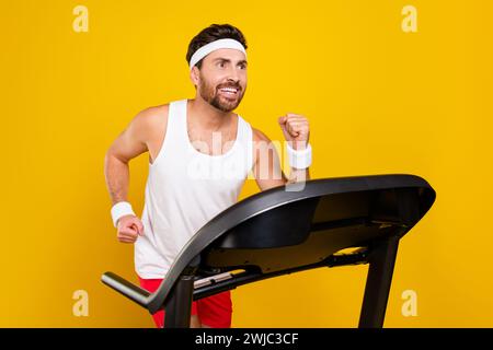 Foto del profilo di un bellissimo e sportivo tapis roulant man run pubblicità a spazi vuoti isolata su sfondo giallo Foto Stock