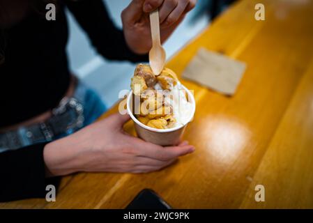 Ragazza che mangia waffle con gelato allo Street food Cafe. Foto Stock