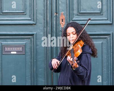 Venezia, Italia - 13 febbraio 2024: Giovane suona il violino nelle strade del centro storico di Venezia durante il carnevale. Artista di strada. Foto Stock