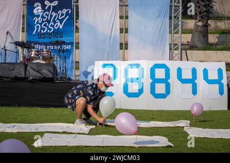 Bangkok, Thailandia. 14 febbraio 2024. Un attivista thailandese si vede aggiustare un pallone a terra durante il Festival dell'Amnesty per San Valentino, nella piazza pubblica. 23 persone appartenenti alle organizzazioni di amnistia, insieme a centinaia di attivisti, volontari e persone comuni, si sono riunite per chiedere la fine del processo contro le persone per l'espressione politica, per ripristinare i loro diritti e la loro libertà e per liberare dalle carceri persone con differenze politiche. (Foto di Nathalie Jamois/SOPA Images/Sipa USA) credito: SIPA USA/Alamy Live News Foto Stock