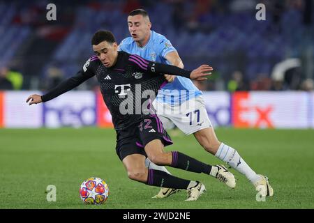 Roma, Italie. 14 febbraio 2024. Jamal Musiala del Bayern Monaco vige per il ballo con Adam Marusic della Lazio durante la UEFA Champions League, sedicesima tappa, partita di calcio tra SS Lazio e Bayern Monaco il 14 febbraio 2024 allo Stadio Olimpico di Roma, Italia - foto Federico Proietti/DPPI credito: media DPPI/Alamy Live News Foto Stock