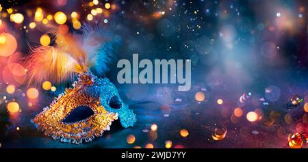 Carnevale - maschera veneziana con luci bokeh - mascheratura travestimento con Confetti su sfondo astratto sfocato Foto Stock
