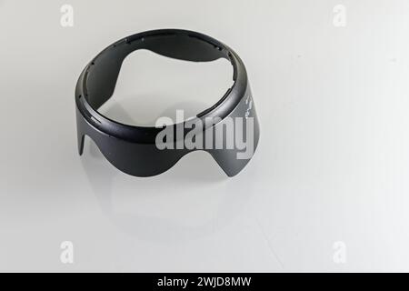 Paraluce obiettivo in plastica nera per l'obiettivo della fotocamera, isolato su sfondo bianco Foto Stock