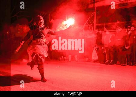 Alsasua, Spagna. 13 febbraio 2024. Una sorgina, una strega basca, corre urlando dando inizio ai 'momotxorros' con un flare che corre lungo il percorso, Alsasua. Credito: SOPA Images Limited/Alamy Live News Foto Stock