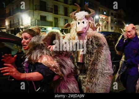 Alsasua, Spagna. 13 febbraio 2024. Un orso e il suo manometto dalla faccia maialino spaventano una ragazza vestita da strega "sorgina" in basco, durante la celebrazione del carnevale di Alsasua. Credito: SOPA Images Limited/Alamy Live News Foto Stock