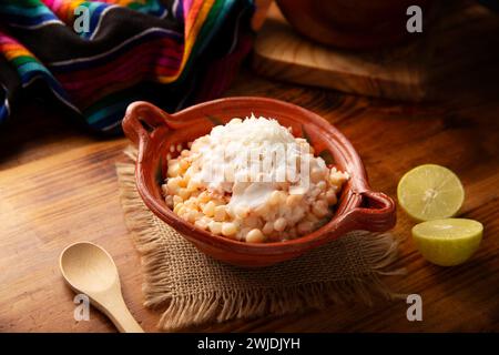 Esquites. Chicchi di mais cotti e serviti con maionese, panna acida, limone e peperoncino in polvere, cibo di strada molto popolare in Messico, noto anche come Elote en Vas Foto Stock