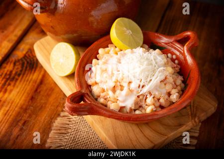 Esquites. Chicchi di mais cotti e serviti con maionese, panna acida, limone e peperoncino in polvere, cibo di strada molto popolare in Messico, noto anche come Elote en Vas Foto Stock