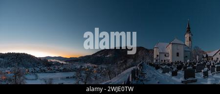 Splendido villaggio di Ljubno ob Savinji, sede di gare femminili di salto con gli sci. Panorama invernale dalla chiesa sopra il villaggio la mattina presto. Dom Foto Stock