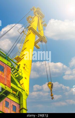 Il braccio della gru del carrello con i ganci e il peso della bilancia alla luce del sole Foto Stock