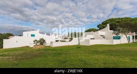 Scenario idilliaco caratterizzato da affascinanti cottage bianchi circondati da lussureggianti prati verdi in una tranquilla località turistica, Algarve, Portogallo Foto Stock