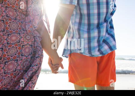 Coppia caucasica che tiene per mano la spiaggia Foto Stock