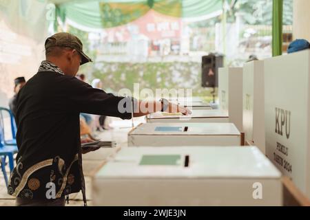 Il residente ha messo la carta elettorale in una scatola durante le elezioni indonesiane Pemilu a Semarang, Indonesia - 14 febbraio 2024. Foto Stock