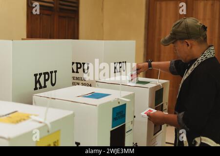 Il residente ha messo la carta elettorale in una scatola durante le elezioni indonesiane Pemilu a Semarang, Indonesia - 14 febbraio 2024. Foto Stock