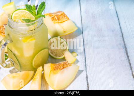 Limonata di melone o mojito, melone e succo di lime, con ghiaccio tritato, fettine di frutta guarnite con foglie di menta. Bevanda estiva biologica fresca, fruttata infusa Foto Stock